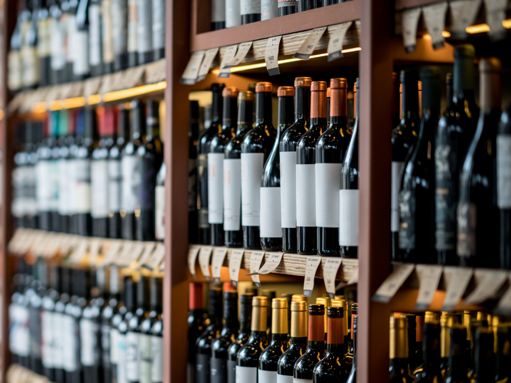 Rows of bottled wine on shelves, representing wine prepared for final filtration and bottling
